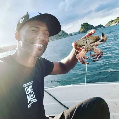 He is posing by holding a crab.